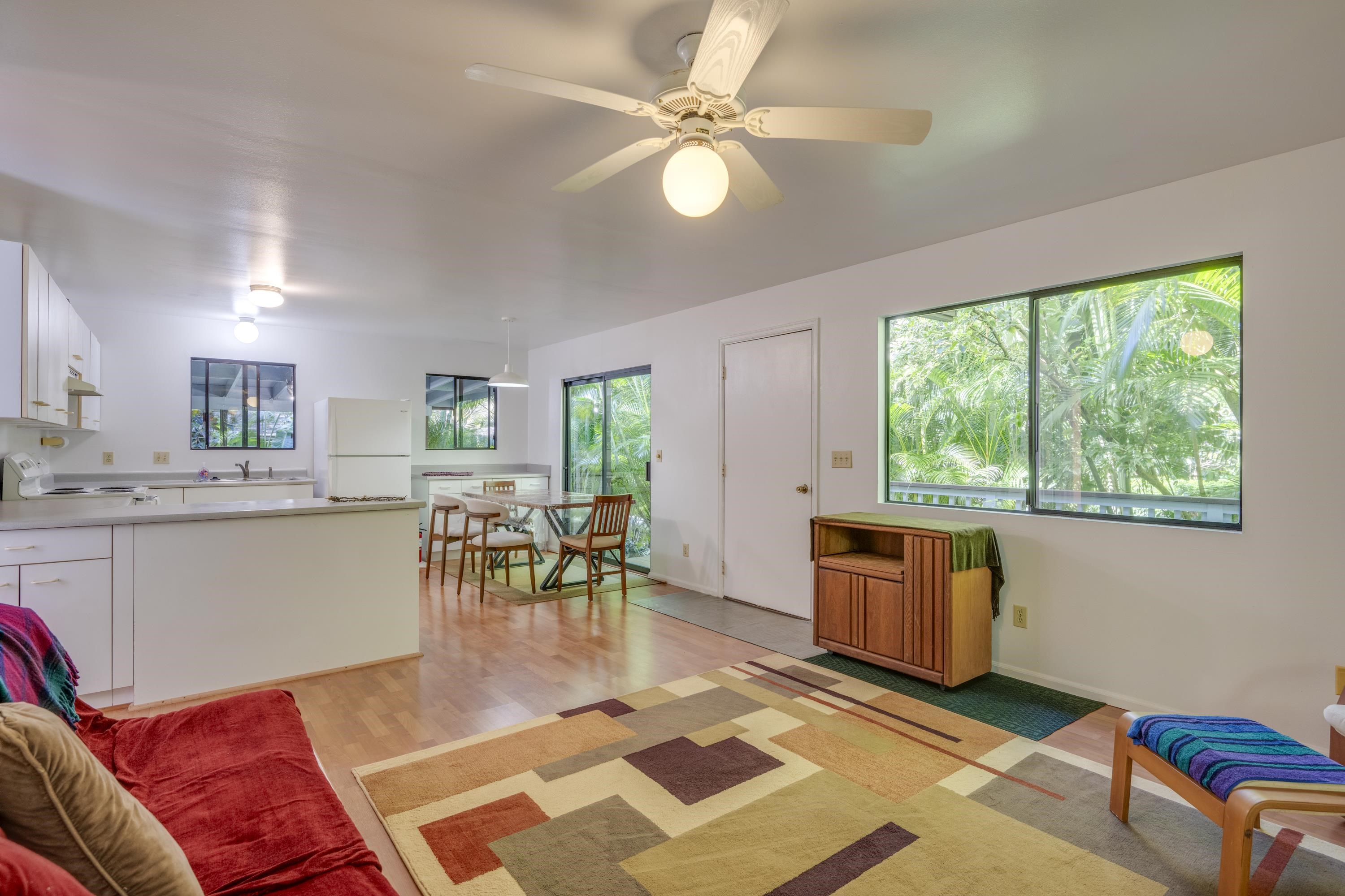 1002 Kauhikoa Road, Unit 2 Haiku, HI 96708 - Photo 18 of 24 a living room with furniture a dining table and a window