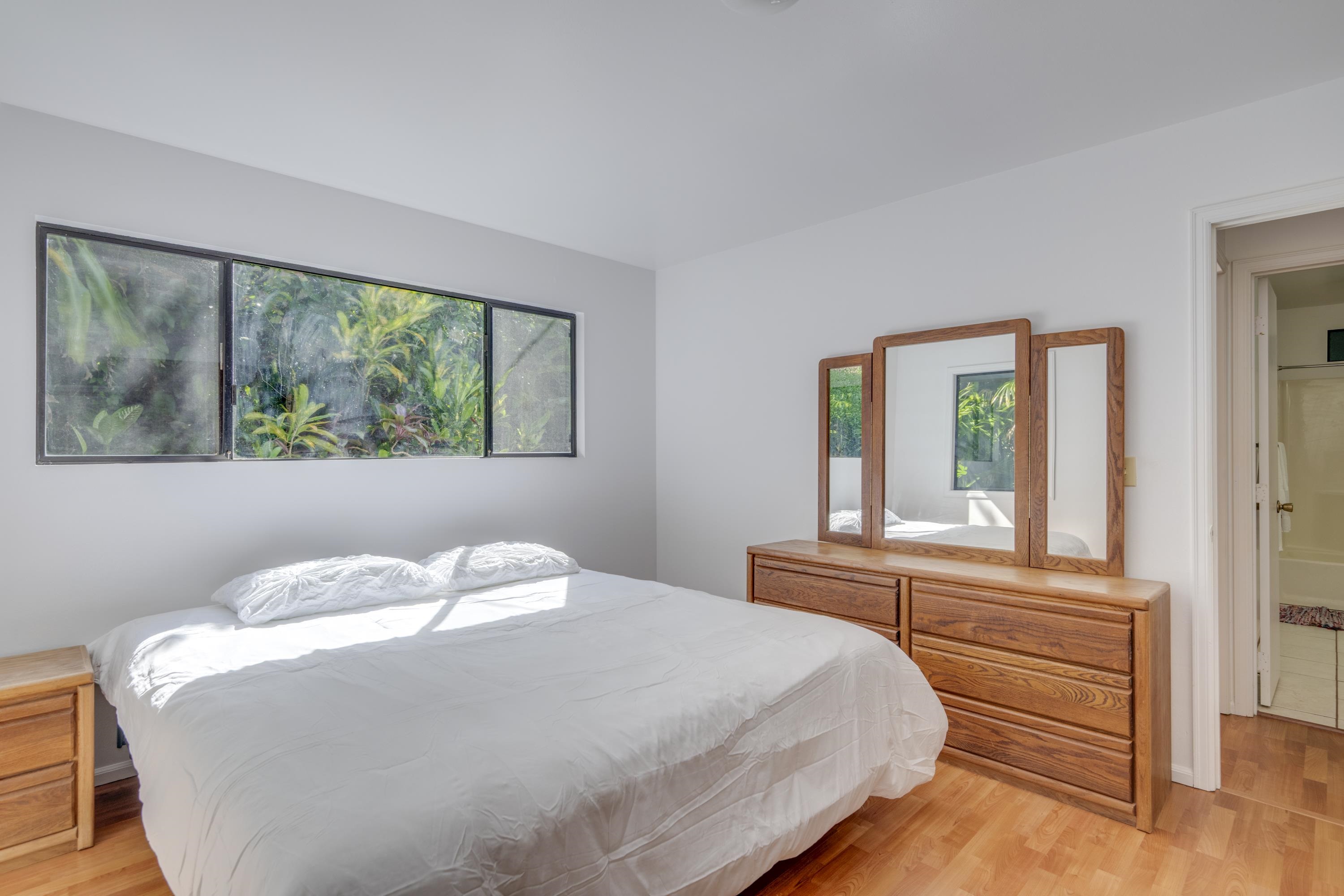 1002 Kauhikoa Road, Unit 2 Haiku, HI 96708 - Photo 19 of 24 a bedroom with a bed and a large window