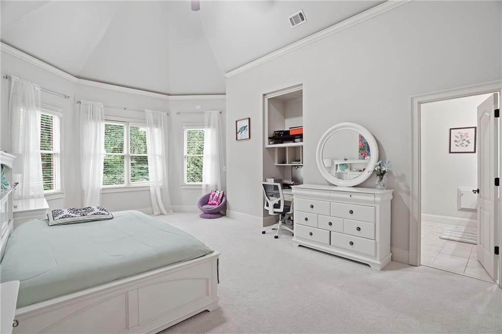 8340 Colonial Place Duluth, GA 30097 - Photo 36 of 74 a spacious bedroom with a bed a dresser and next to a window