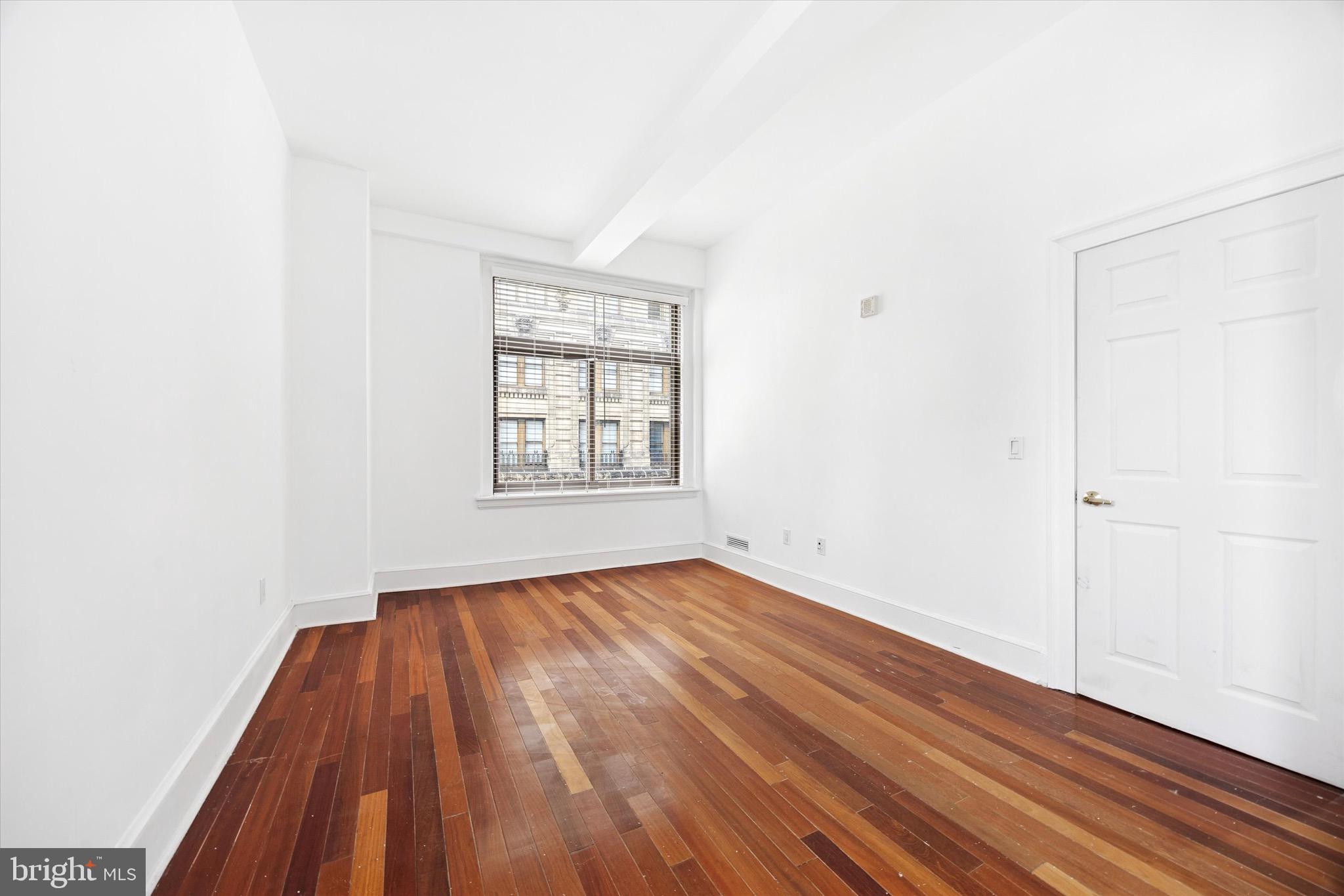 1500 Chestnut Street, Unit 15H Philadelphia, PA 19102 - Photo 15 of 25 an empty room with wooden floor and windows