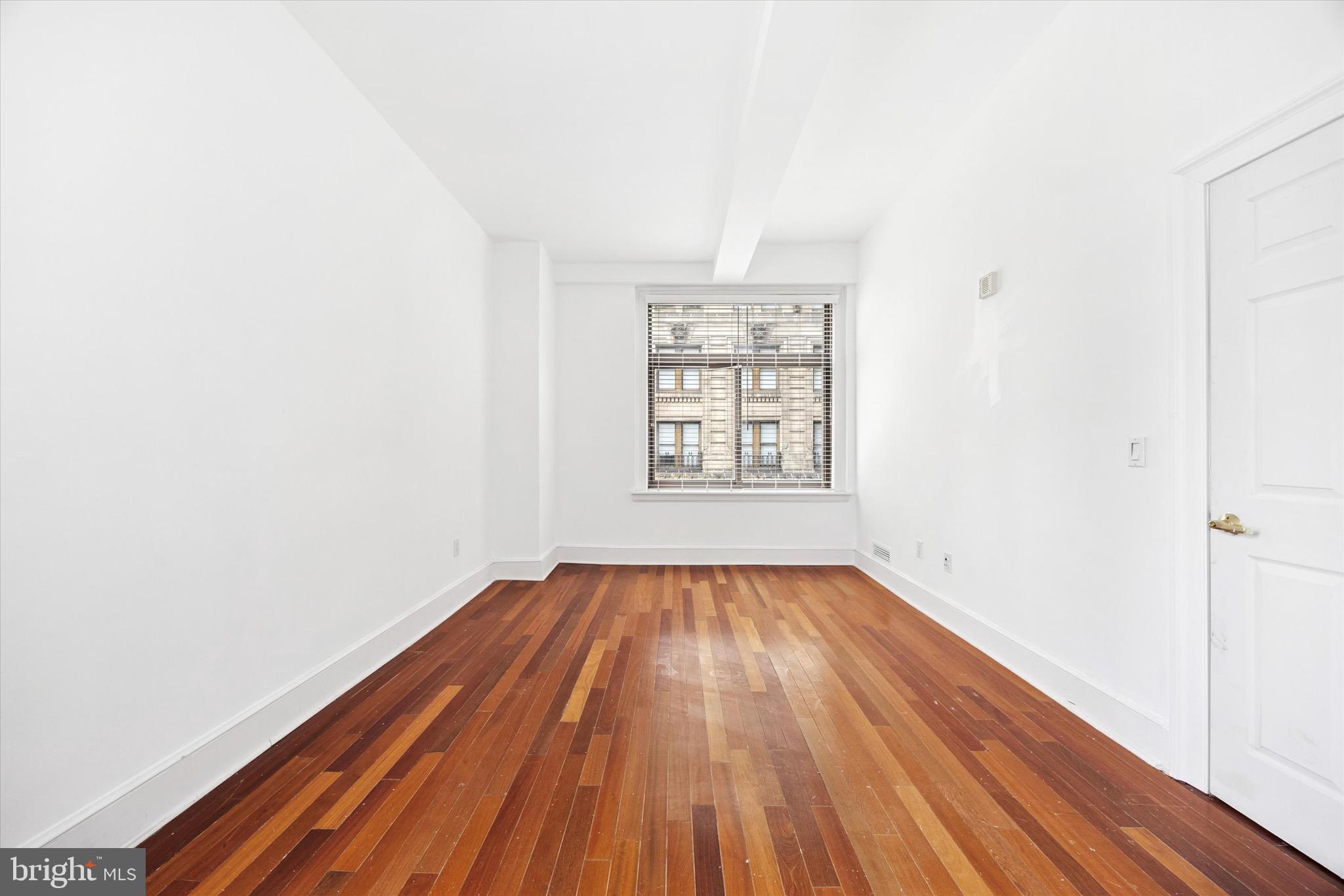 1500 Chestnut Street, Unit 15H Philadelphia, PA 19102 - Photo 17 of 25 an empty room with wooden floor and windows