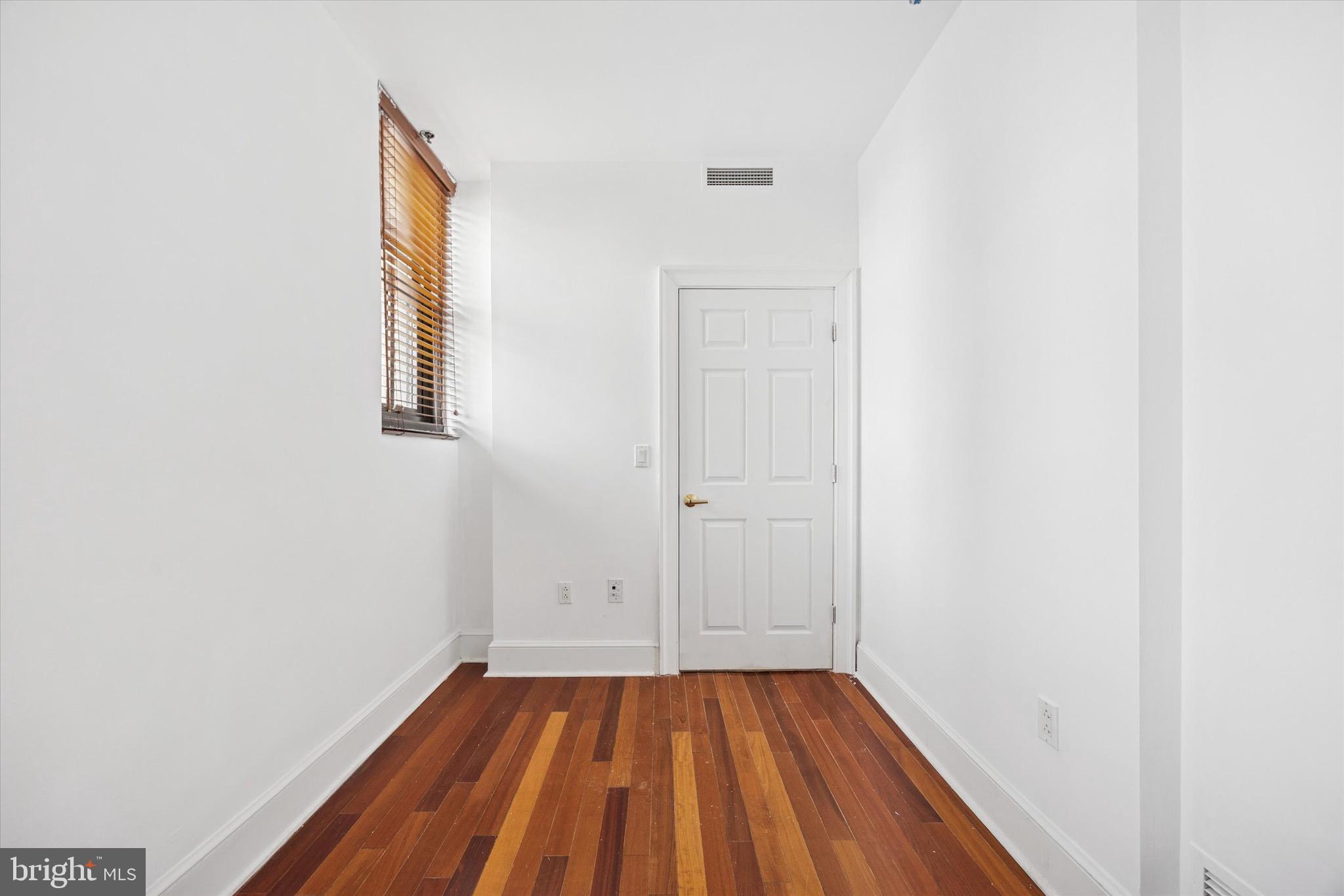 1500 Chestnut Street, Unit 15H Philadelphia, PA 19102 - Photo 22 of 25 a view of an empty room with wooden floor and a window