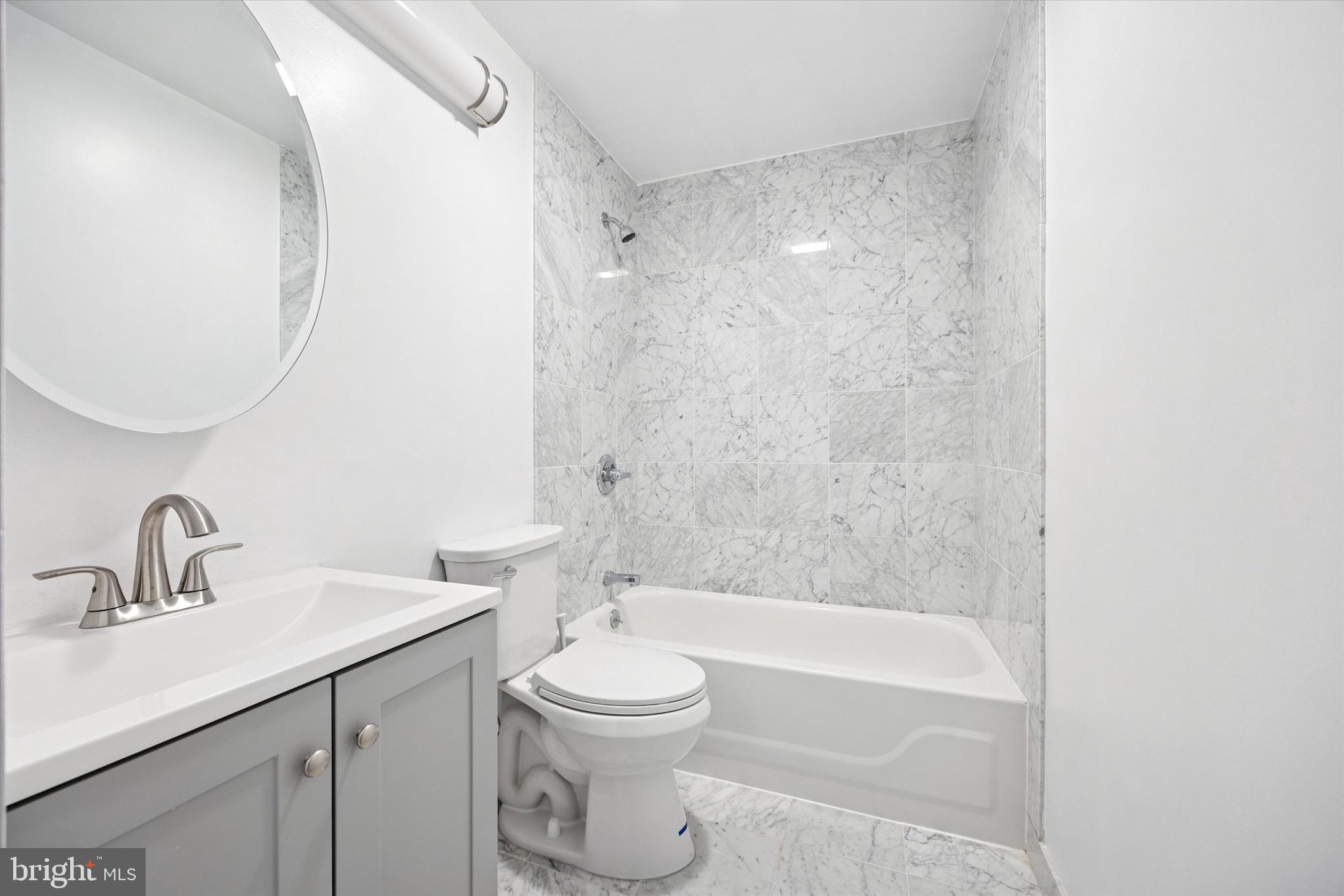 1500 Chestnut Street, Unit 15H Philadelphia, PA 19102 - Photo 24 of 25 a bathroom with a bathtub shower sink vanity mirror and toilet