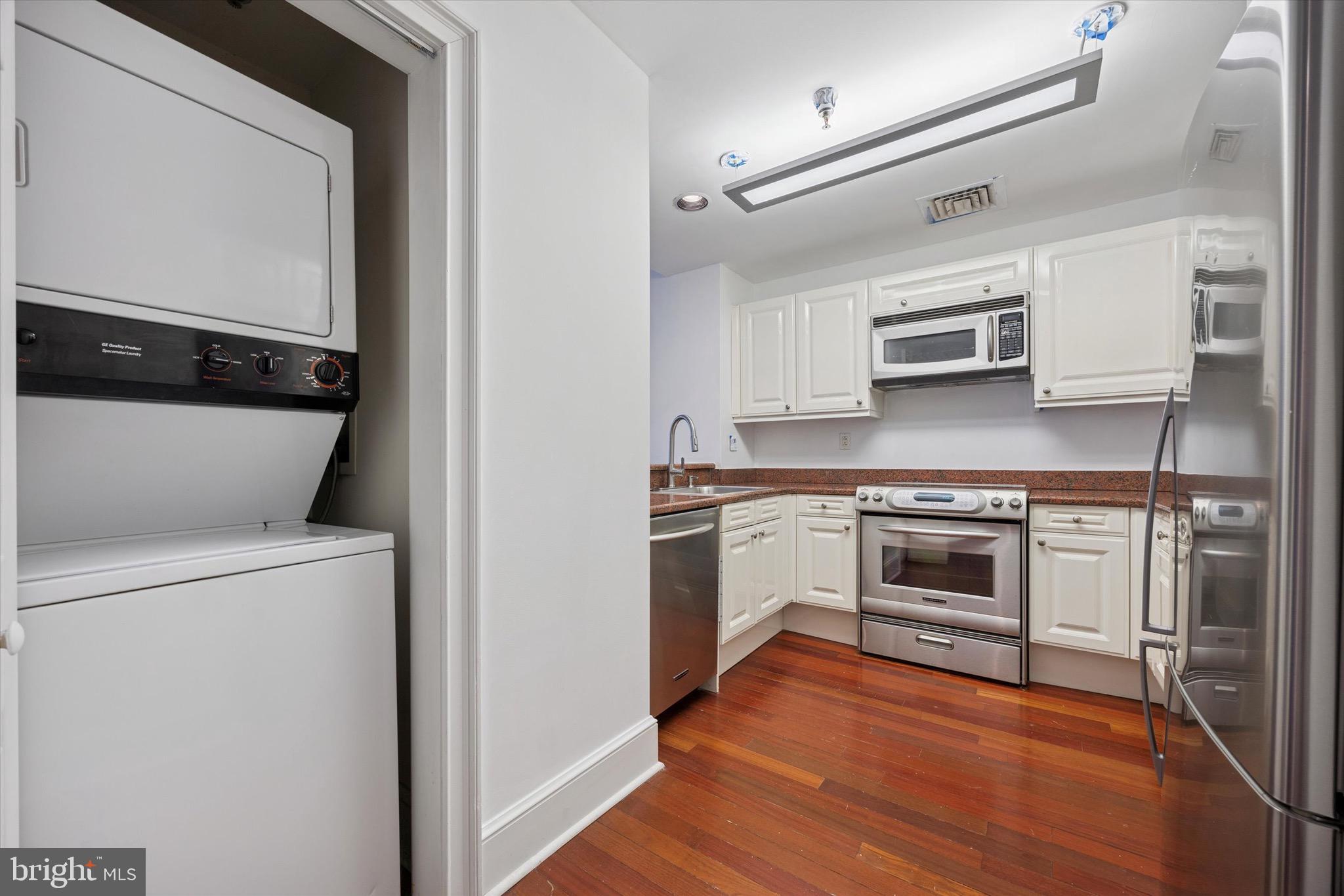 1500 Chestnut Street, Unit 15H Philadelphia, PA 19102 - Photo 4 of 25 a kitchen with cabinets stainless steel appliances and wooden floor