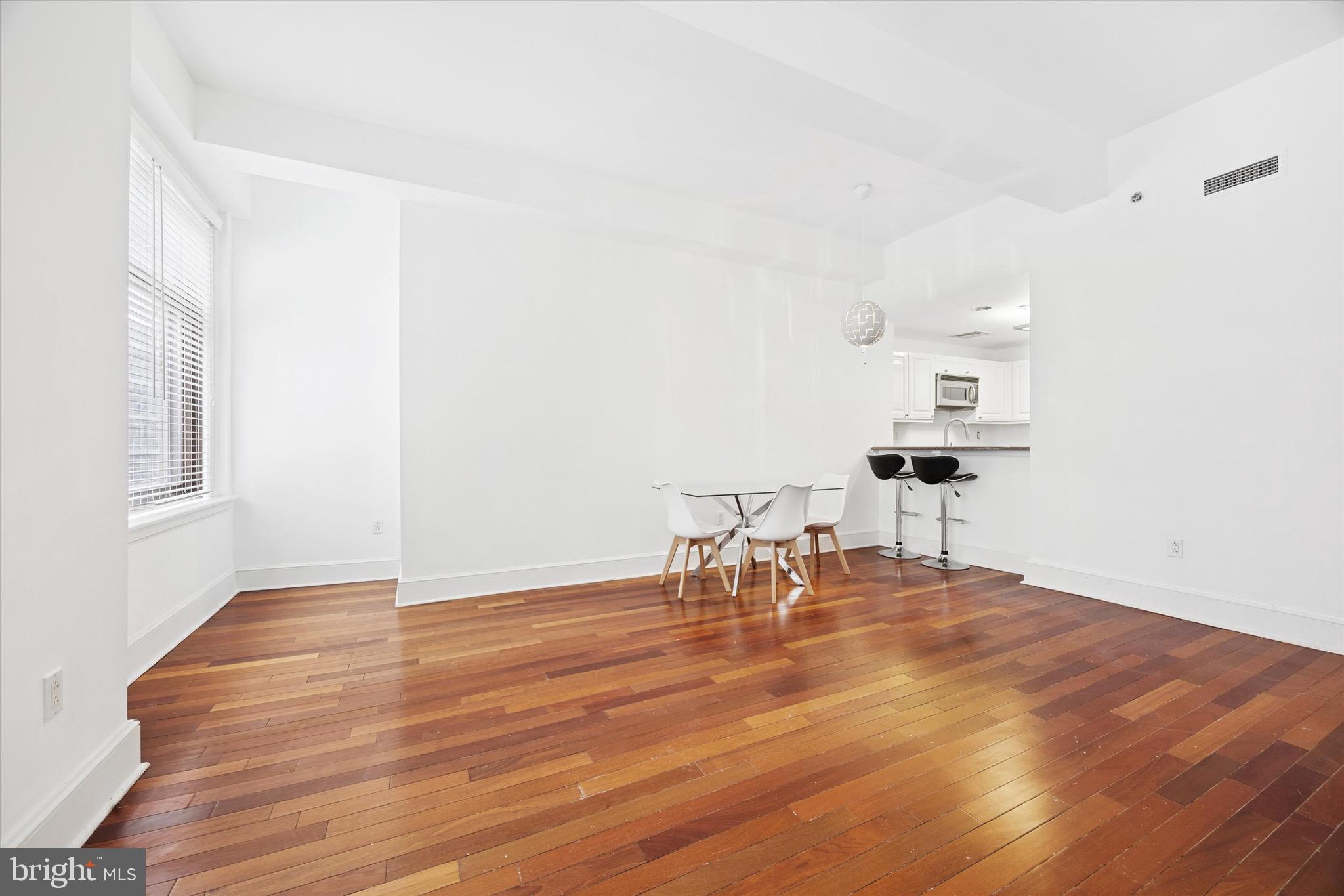 1500 Chestnut Street, Unit 15H Philadelphia, PA 19102 - Photo 7 of 25 a view of a room with wooden floor table and chairs