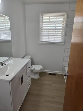 a bathroom with a sink toilet and window