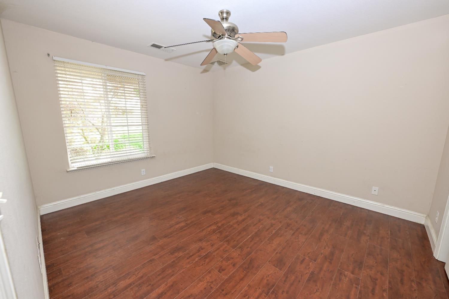 21088 Forest Glen Road Madera, CA 93638 - Photo 11 of 31 wooden floor in an empty room with a window