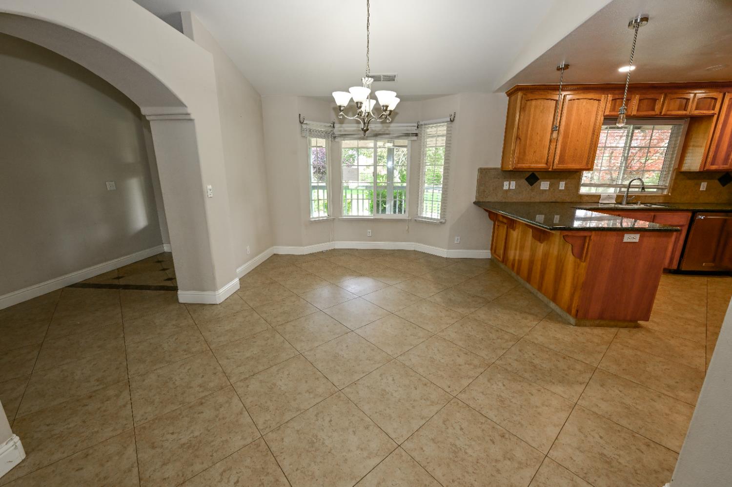 21088 Forest Glen Road Madera, CA 93638 - Photo 9 of 31 a large kitchen with kitchen island granite countertop a stove a sink a window and a dining table
