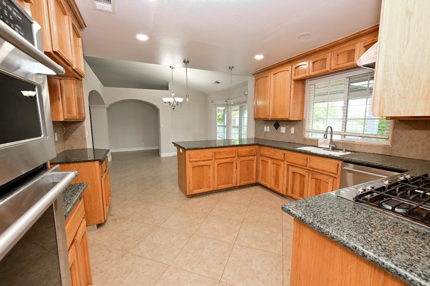 21088 Forest Glen Road Madera, CA 93638 - Photo 10 of 31 a large kitchen with stainless steel appliances granite countertop a sink and a counter space