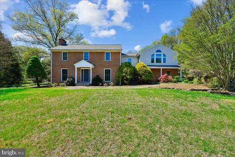 a front view of a house with yard and trees