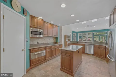 a kitchen with stainless steel appliances granite countertop a refrigerator and a sink