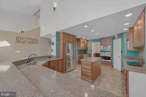 a kitchen with stainless steel appliances granite countertop a refrigerator and a sink