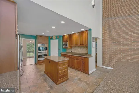 a kitchen with stainless steel appliances granite countertop a refrigerator a sink and a stove
