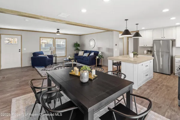 a kitchen with stainless steel appliances granite countertop a table chairs and a refrigerator