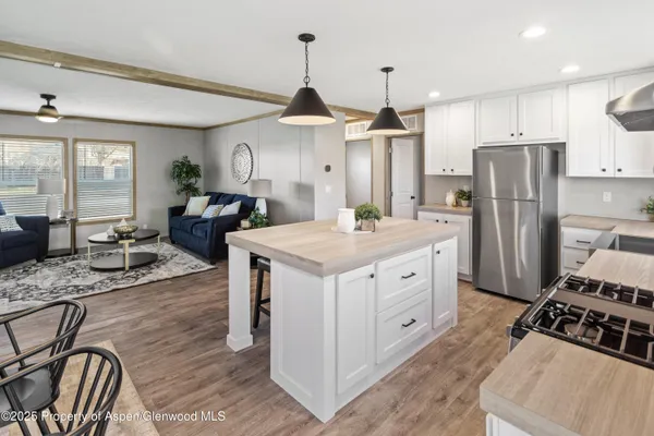 a kitchen with stainless steel appliances granite countertop a stove refrigerator and cabinets
