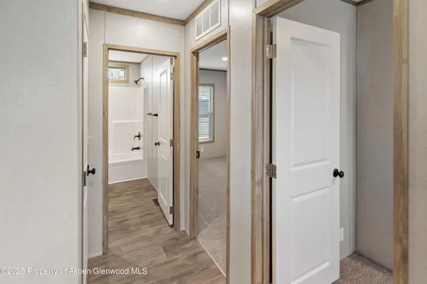 a view of a bathroom from a hallway with a wooden door