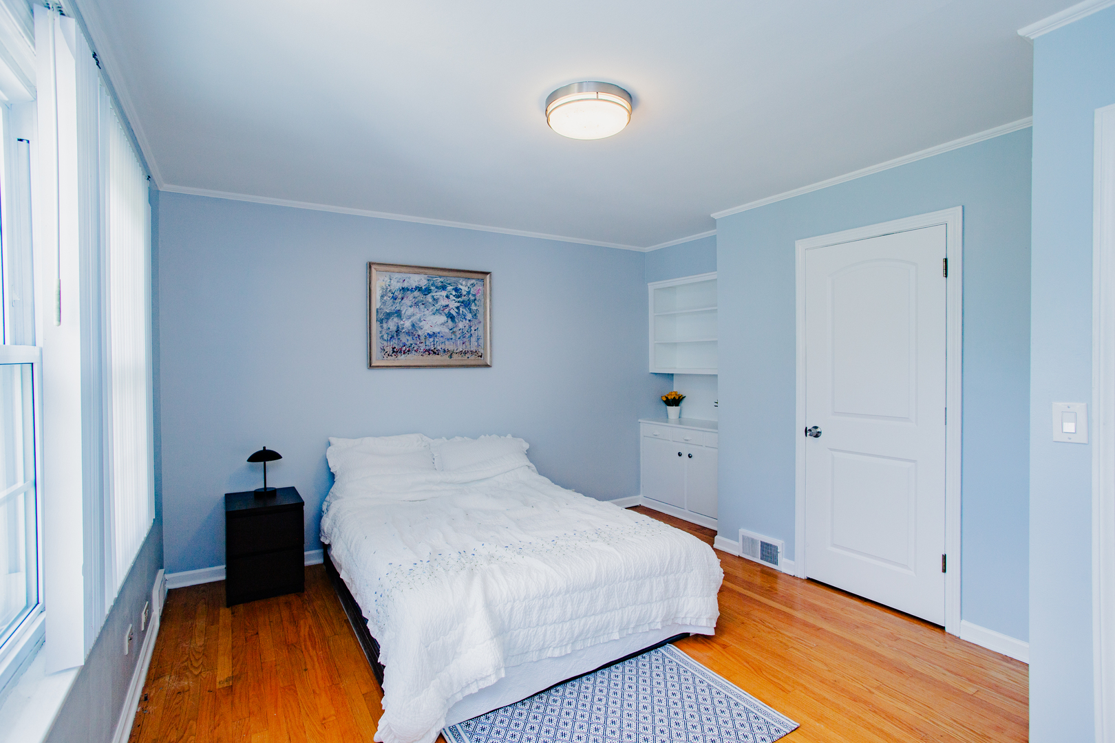 1749 North Happ Road Northbrook, IL 60062 - Photo 13 of 27 a bedroom with a bed and a lamp on dresser