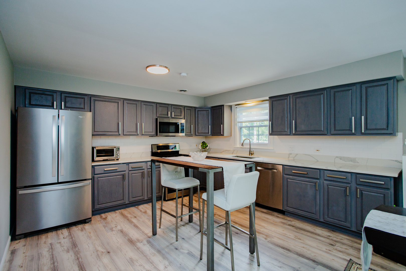 1749 North Happ Road Northbrook, IL 60062 - Photo 8 of 27 a kitchen with stainless steel appliances granite countertop a refrigerator a sink dishwasher a stove and white countertops with wooden floor