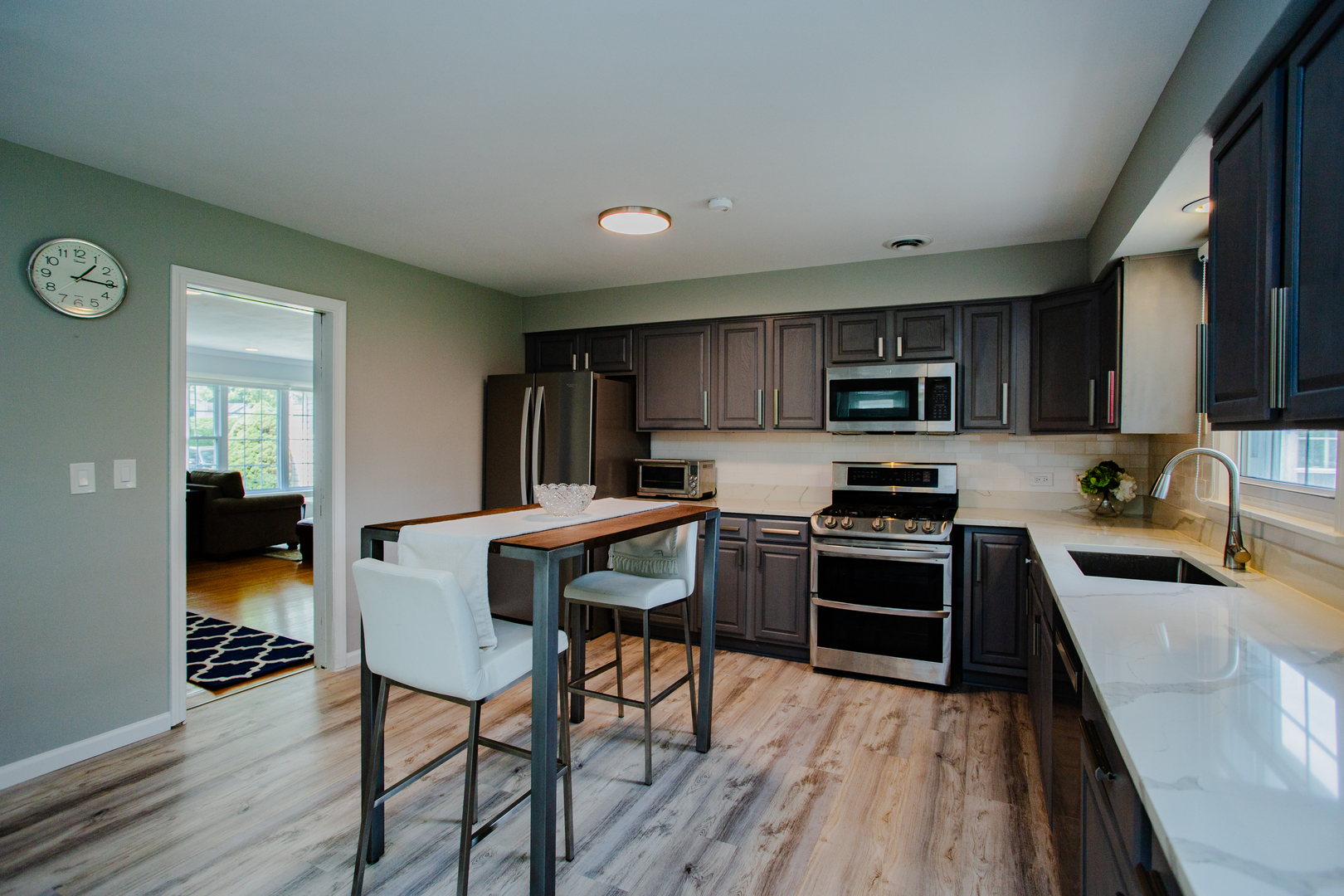1749 North Happ Road Northbrook, IL 60062 - Photo 9 of 27 a kitchen with stainless steel appliances granite countertop a stove top oven a sink dishwasher a dining table and chairs with wooden floor