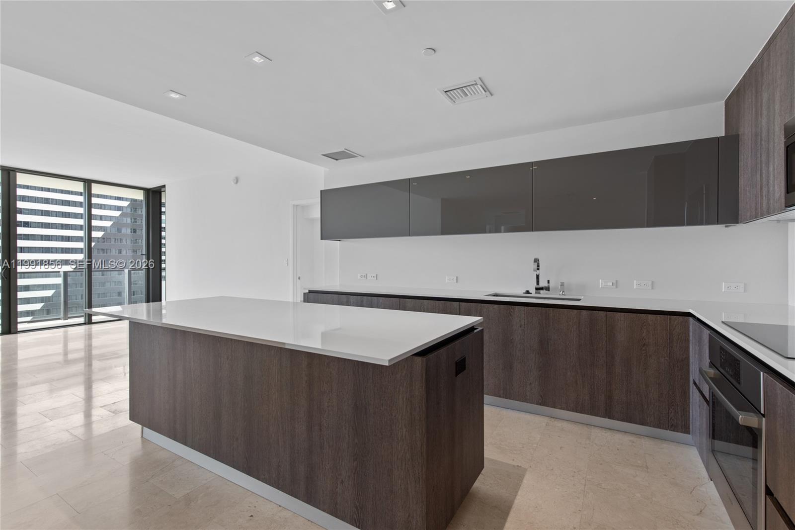 88 Southwest 7th Street, Unit 904 Miami, FL 33130 - Photo 3 of 34 a kitchen with a sink dishwasher and a stove with wooden floor