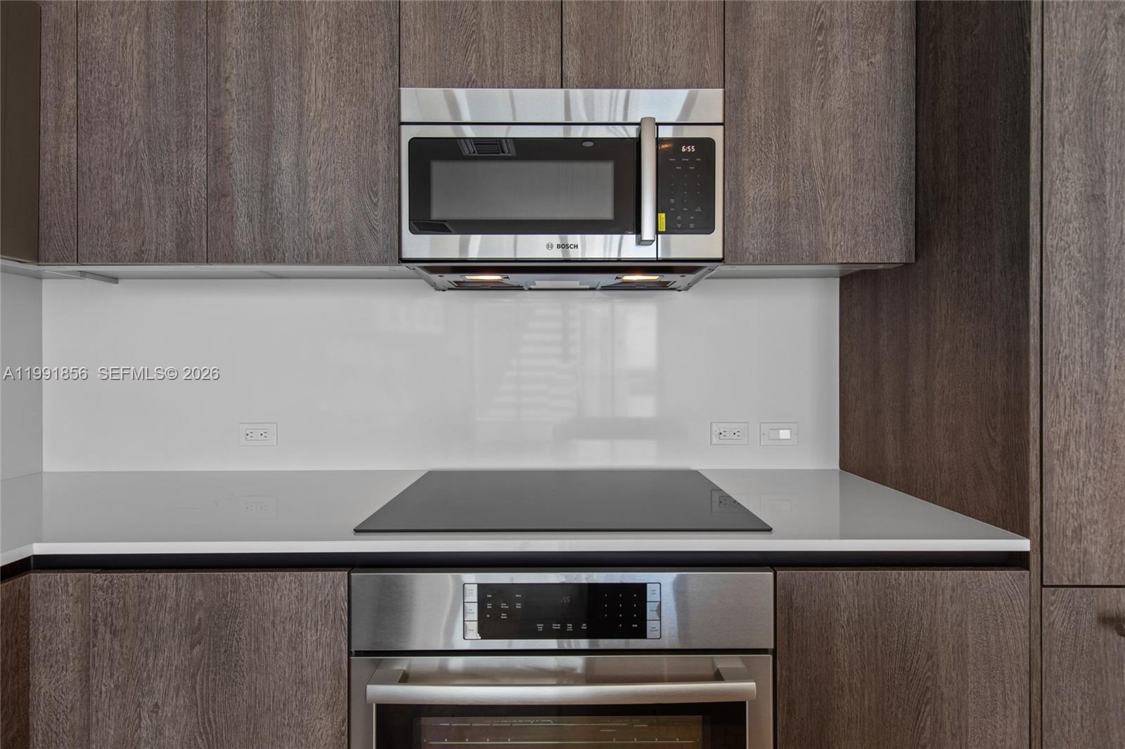 88 Southwest 7th Street, Unit 904 Miami, FL 33130 - Photo 6 of 34 a kitchen with a stove and a microwave