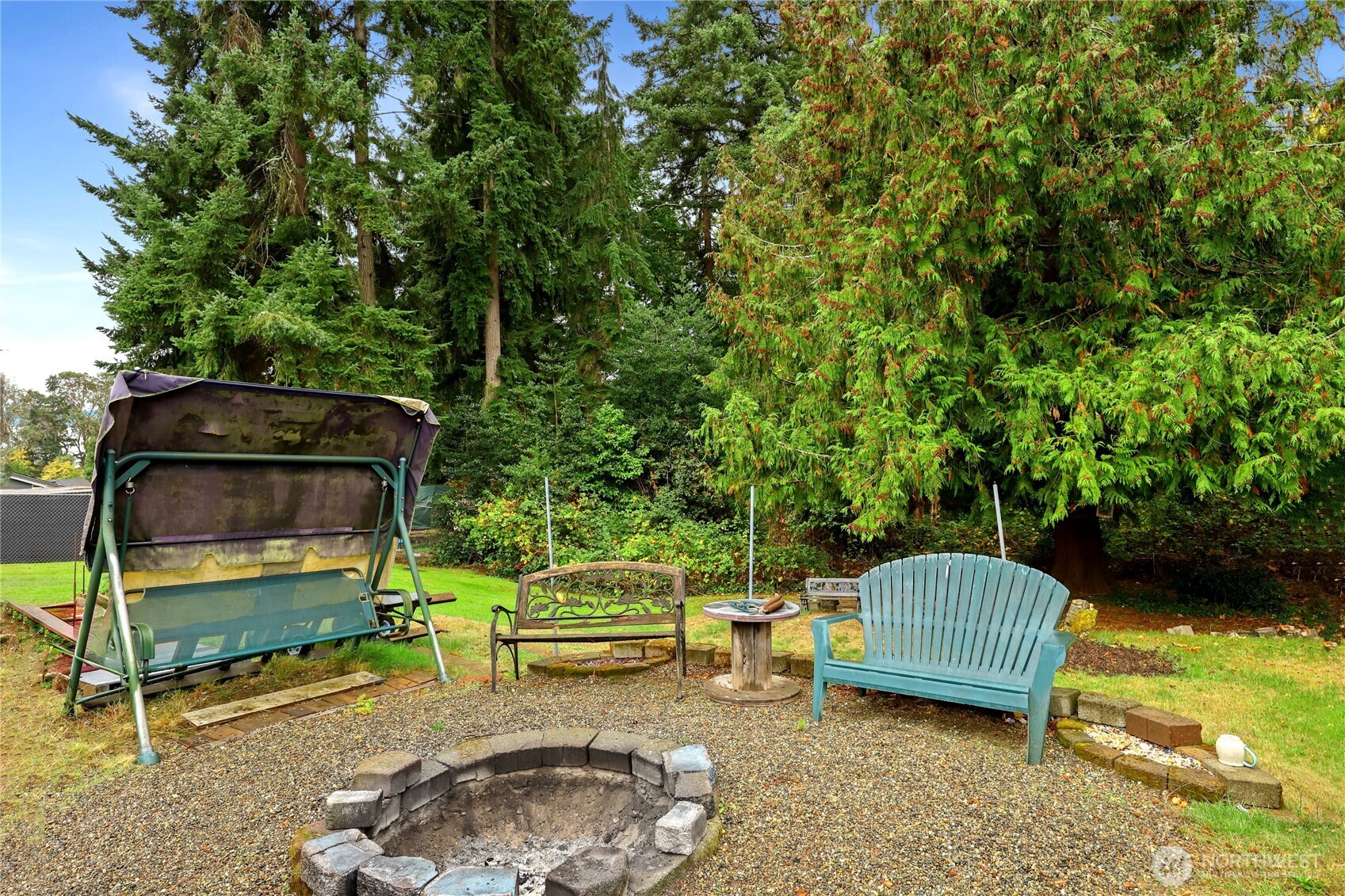 2853 Clare Avenue Bremerton, WA 98310 - Photo 18 of 21 a view of a backyard with lawn chairs and a fire pit