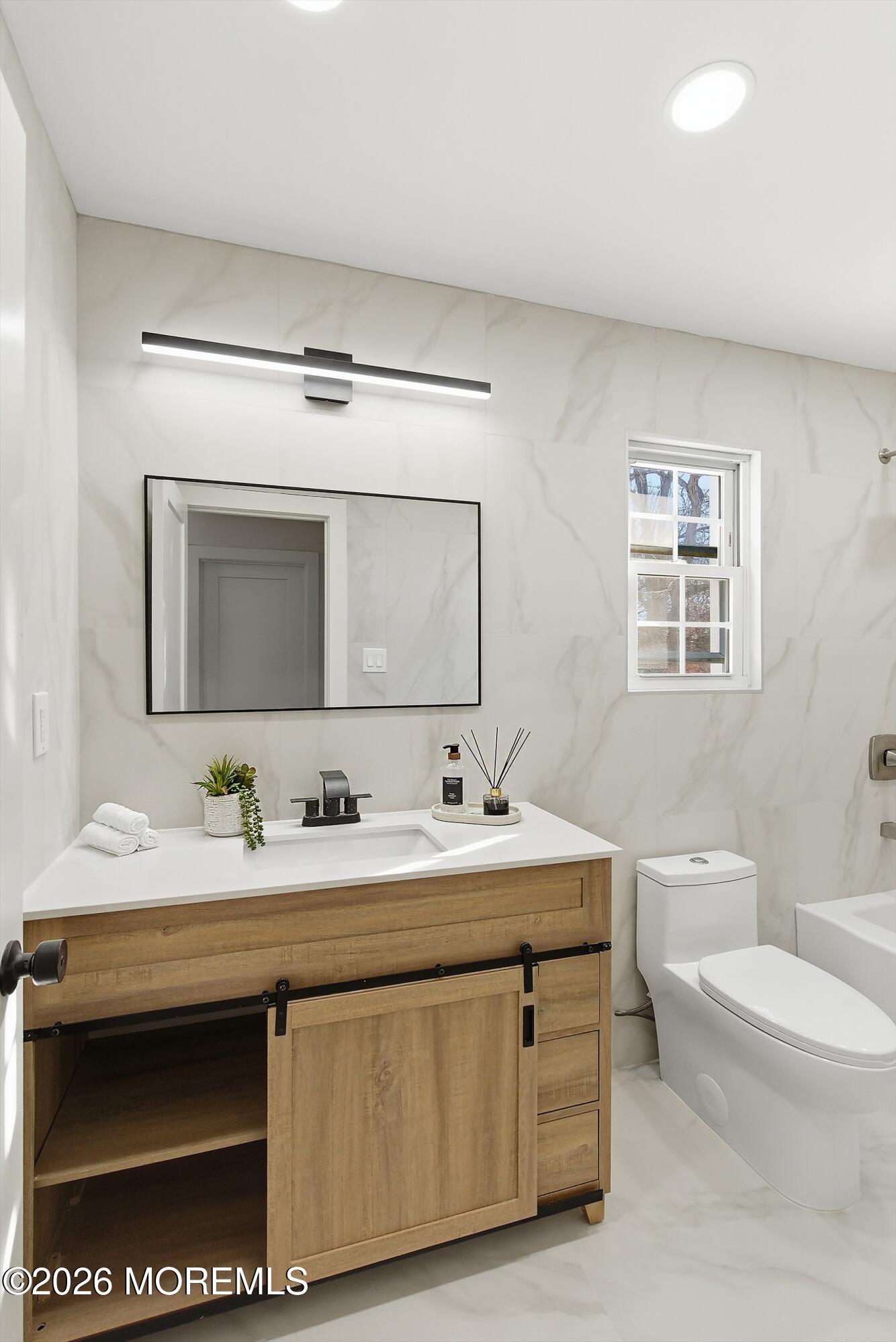 16 6th Street Barnegat, NJ 08005 - Photo 30 of 36 a bathroom with a sink a toilet a mirror and a window