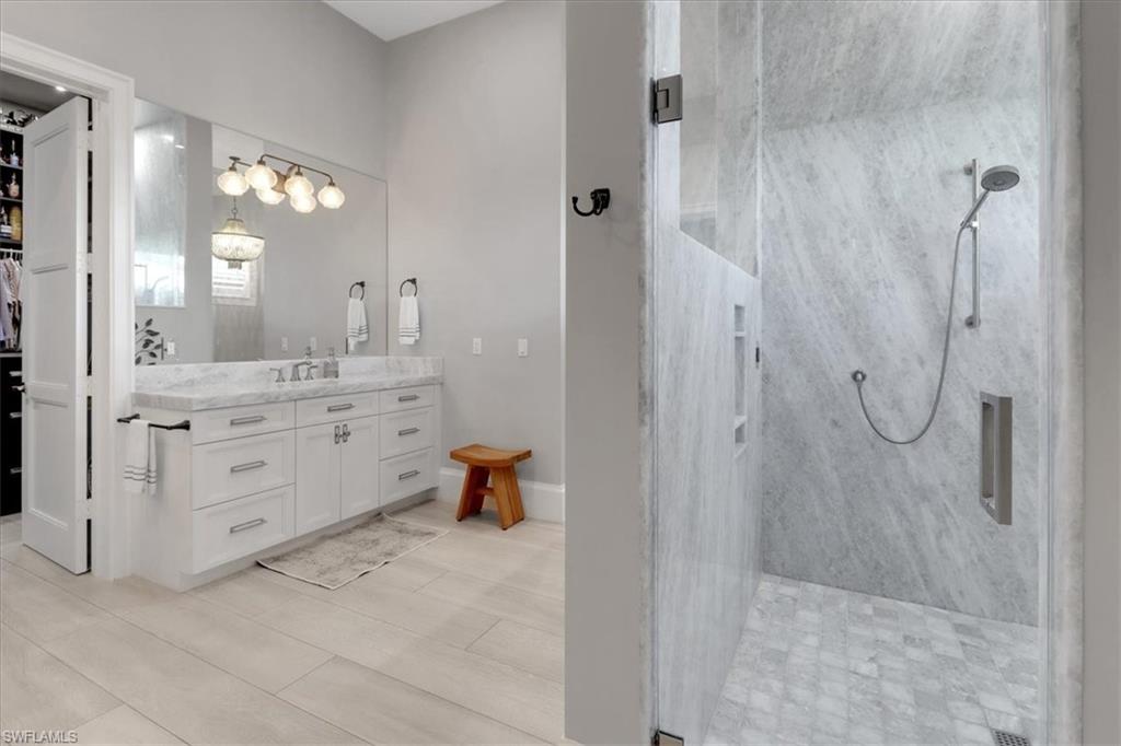 1425 Crayton Road Naples, FL 34102 - Photo 12 of 31 Bathroom with vanity, tile patterned flooring, and a tile shower