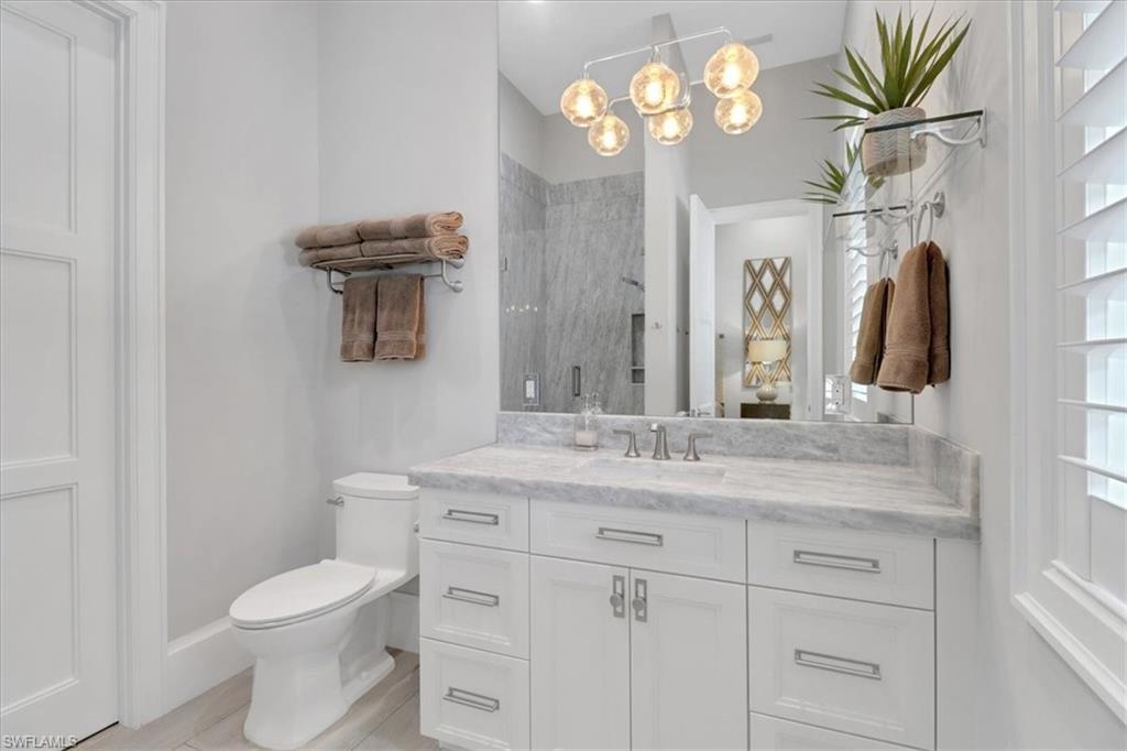 1425 Crayton Road Naples, FL 34102 - Photo 14 of 31 Bathroom featuring toilet, vanity, and walk in shower