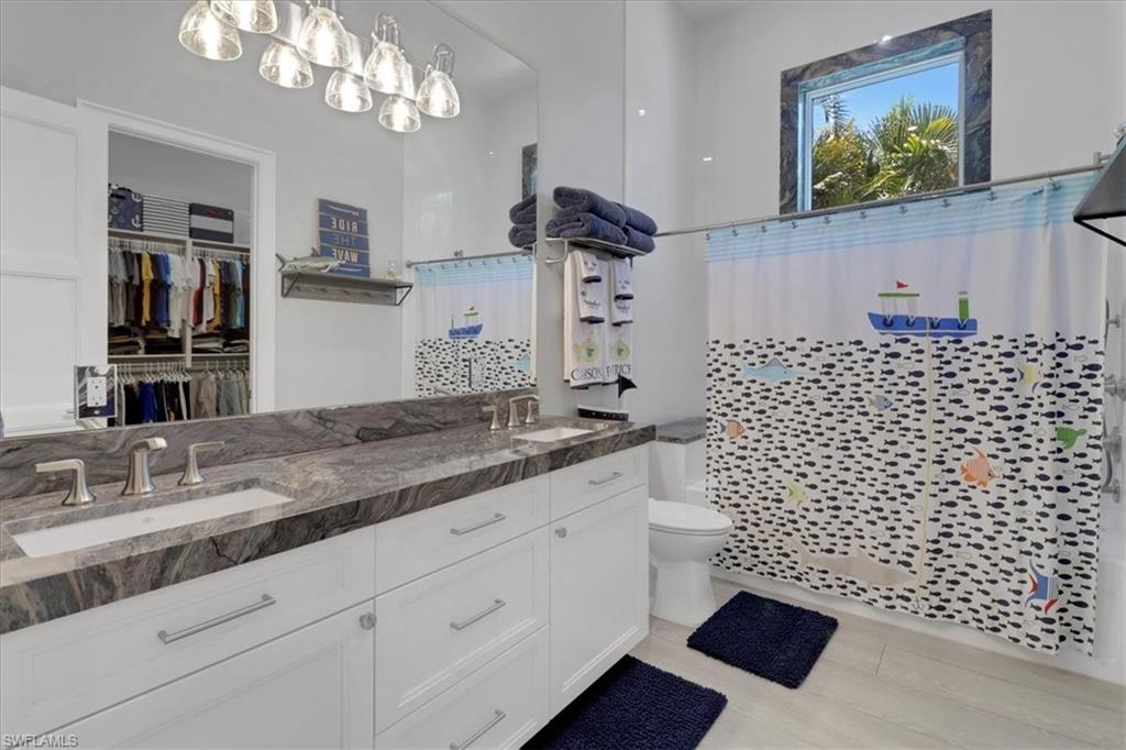 1425 Crayton Road Naples, FL 34102 - Photo 16 of 31 Bathroom featuring toilet, a shower with curtain, and vanity
