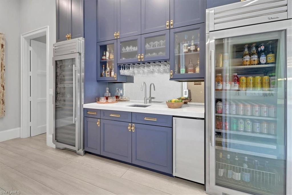 1425 Crayton Road Naples, FL 34102 - Photo 23 of 31 Bar featuring blue cabinets, stainless steel built in fridge, sink, and stainless steel fridge