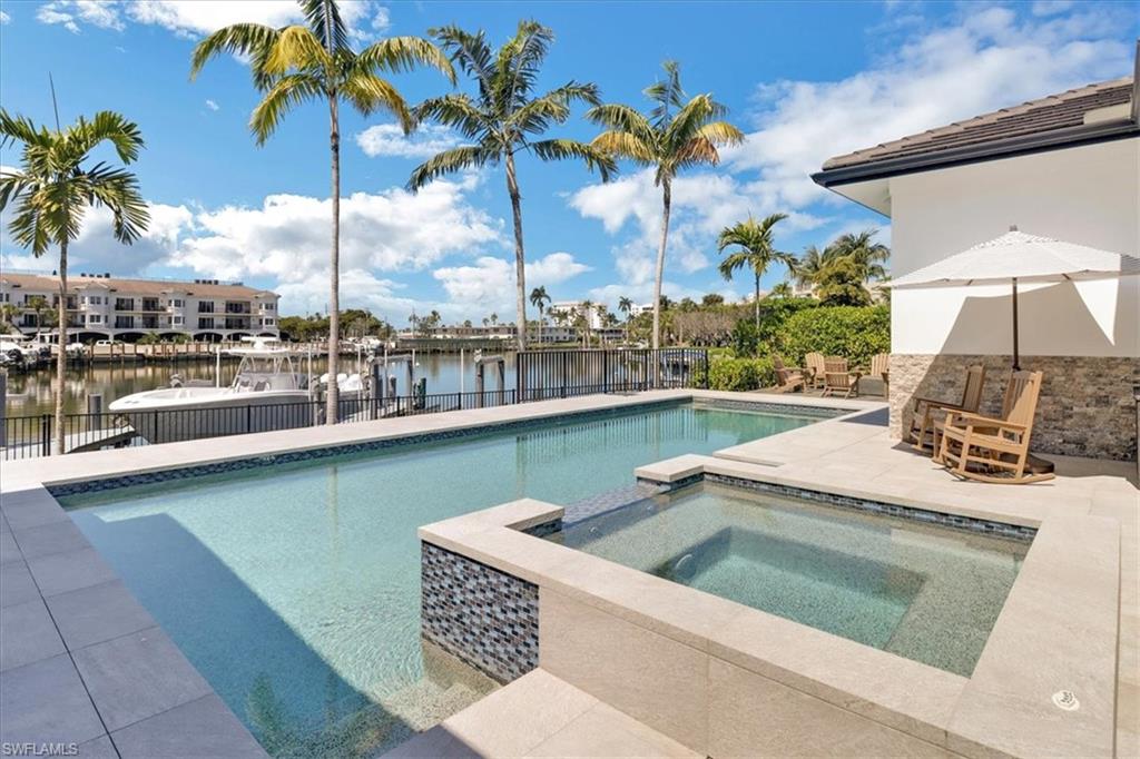 1425 Crayton Road Naples, FL 34102 - Photo 26 of 31 View of pool with a water view, an in ground hot tub, and a patio area