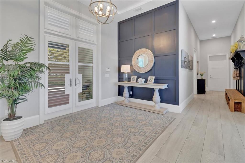 1425 Crayton Road Naples, FL 34102 - Photo 3 of 31 Entryway with light wood-type flooring and a chandelier