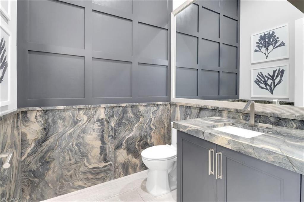 1425 Crayton Road Naples, FL 34102 - Photo 9 of 31 Bathroom with tile patterned floors, vanity, toilet, and tile walls