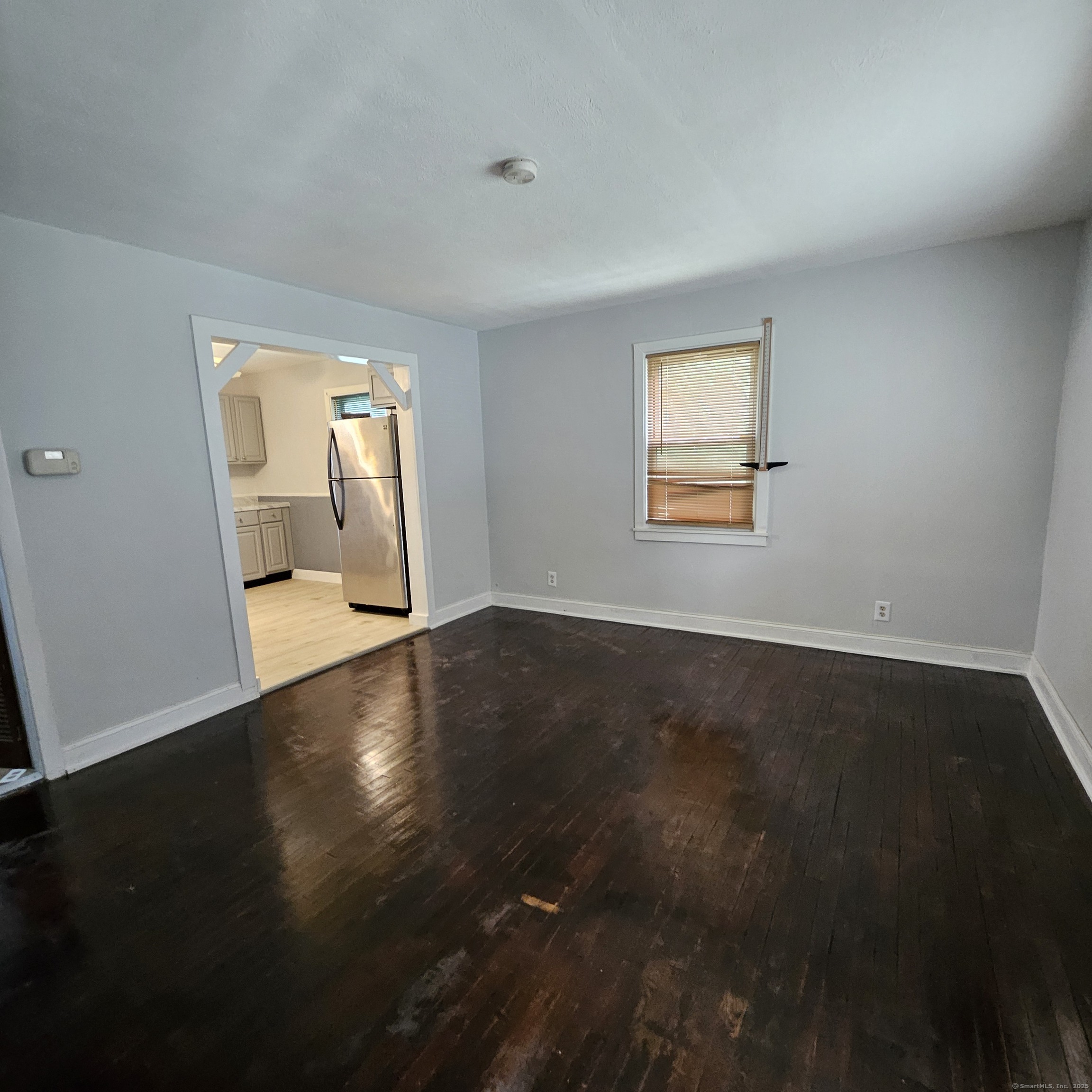 430 Pearl Harbor Street Bridgeport, CT 06610 - Photo 3 of 12 a view of an empty room with wooden floor and a window