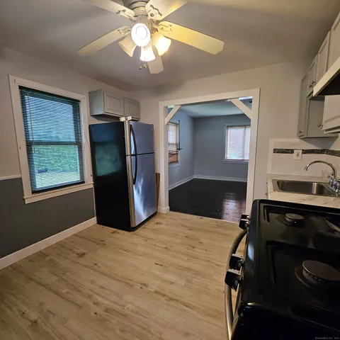 a kitchen with stainless steel appliances granite countertop a refrigerator a stove and a sink with cabinets