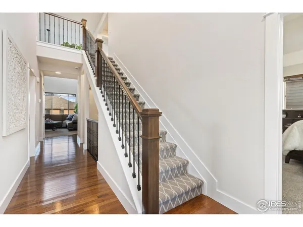 a view of a hallway with wooden floor and staircase