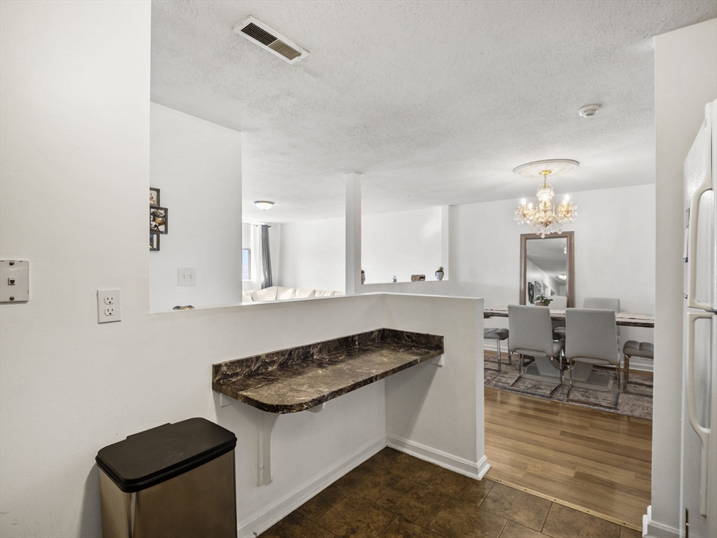 34 Newhall Street, Unit 412 Lowell, MA 01852 - Photo 11 of 30 a kitchen with granite countertop a sink stove and cabinets