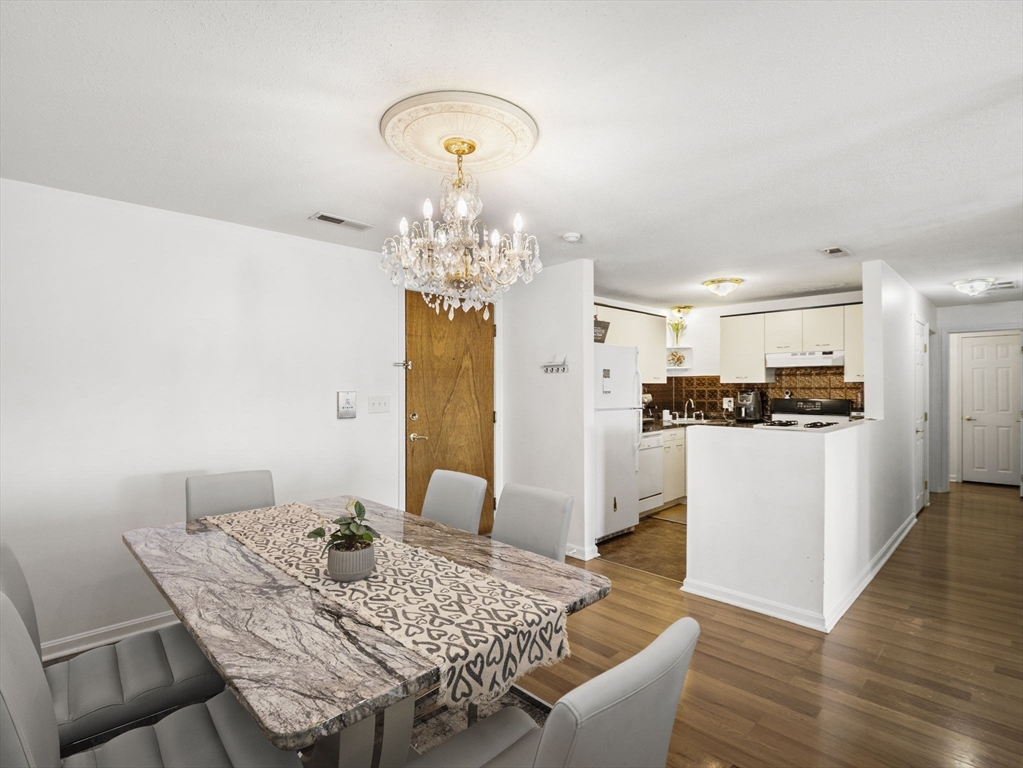 34 Newhall Street, Unit 412 Lowell, MA 01852 - Photo 14 of 30 a view of a dining room with furniture and wooden floor