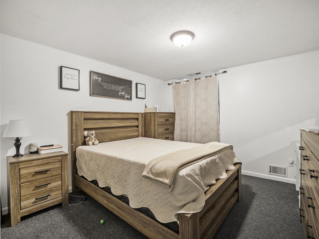34 Newhall Street, Unit 412 Lowell, MA 01852 - Photo 17 of 30 a bedroom with a bed and a cabinets
