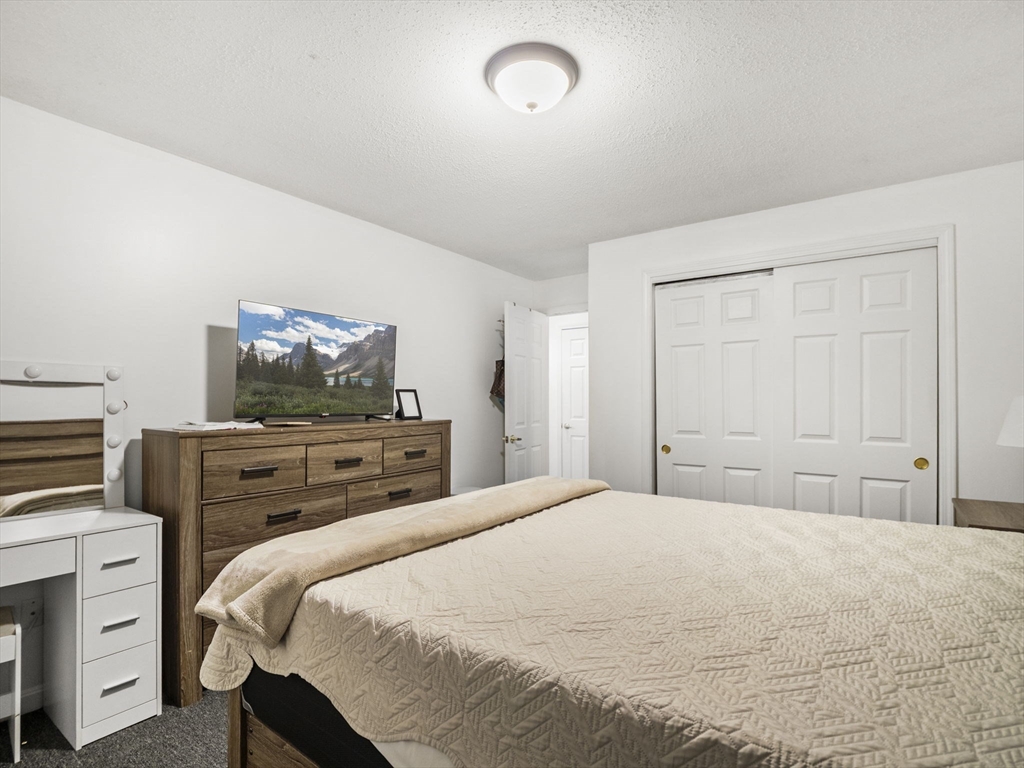 34 Newhall Street, Unit 412 Lowell, MA 01852 - Photo 20 of 30 a bedroom with a bed and furniture