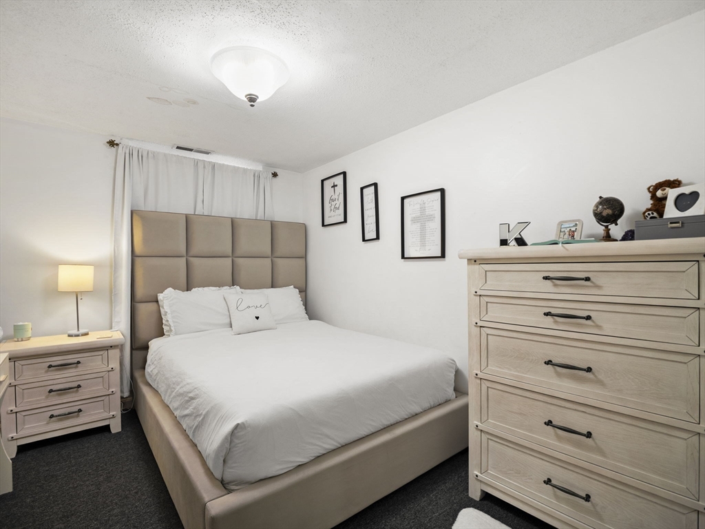 34 Newhall Street, Unit 412 Lowell, MA 01852 - Photo 21 of 30 a bedroom with a bed and a night stand