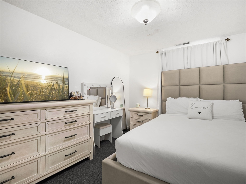 34 Newhall Street, Unit 412 Lowell, MA 01852 - Photo 22 of 30 a bedroom with a bed and a flat screen tv