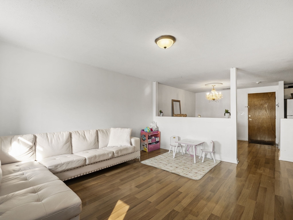 34 Newhall Street, Unit 412 Lowell, MA 01852 - Photo 5 of 30 a living room with furniture and wooden floor
