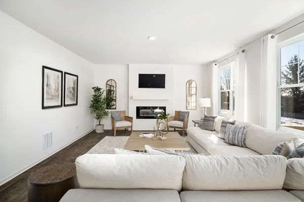 a living room with furniture potted plant a flat screen tv and a fireplace