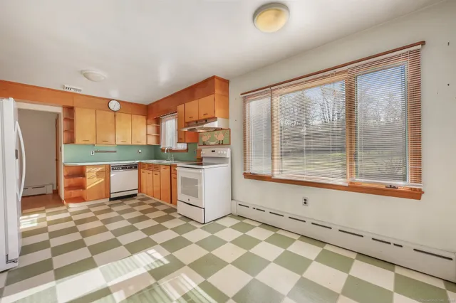 a kitchen with a sink a stove a refrigerator and a window