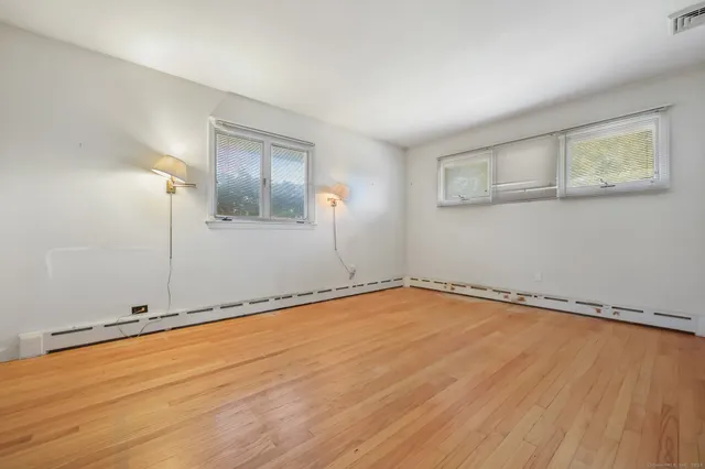 a view of an empty room with wooden floor
