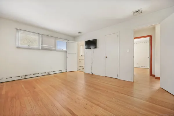 a view of an empty room with wooden floor