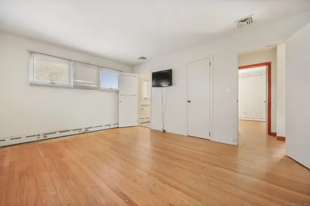 a view of an empty room with wooden floor