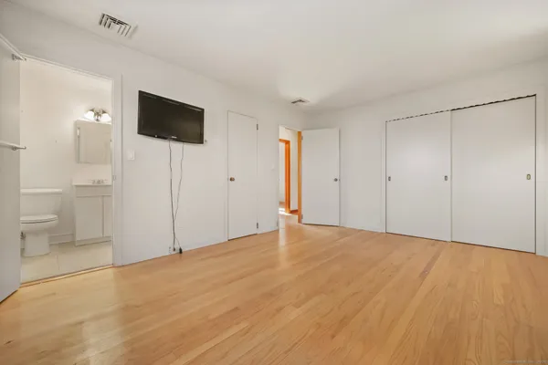 a view of empty room with wooden floor and windows